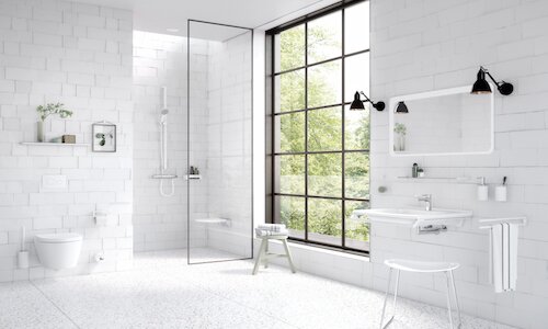 Badezimmer mit weißen Fliesen und weißen Sanitärobjekten.