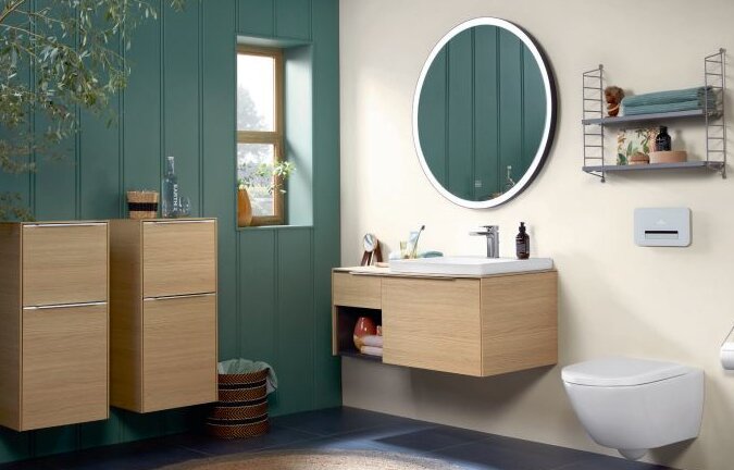 Bad mit Holzmöbeln und grün gestrichener Wand